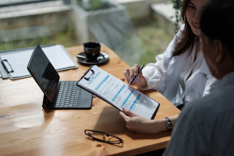 Person reviewing insurance paperwork and rehab treatment costs with an advisor, representing insurance coverage and payment options for addiction rehab.