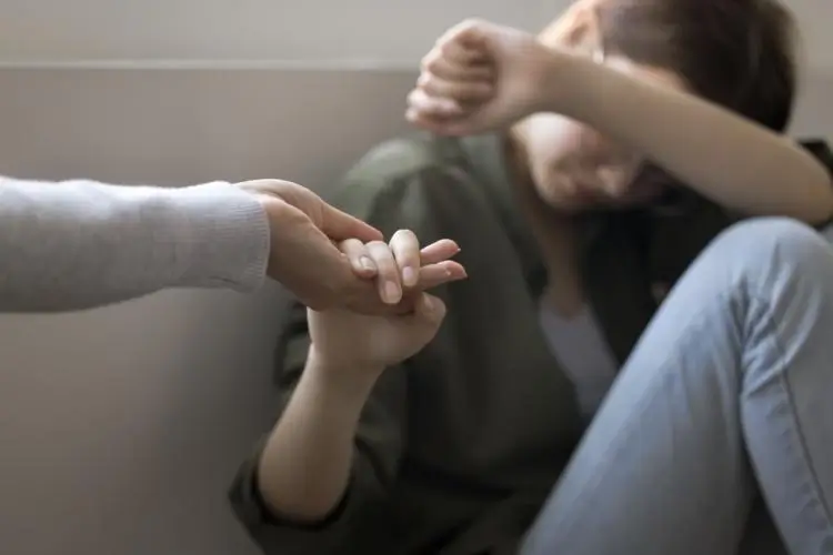 Person reaching out to comfort someone in distress, representing support for fentanyl addiction