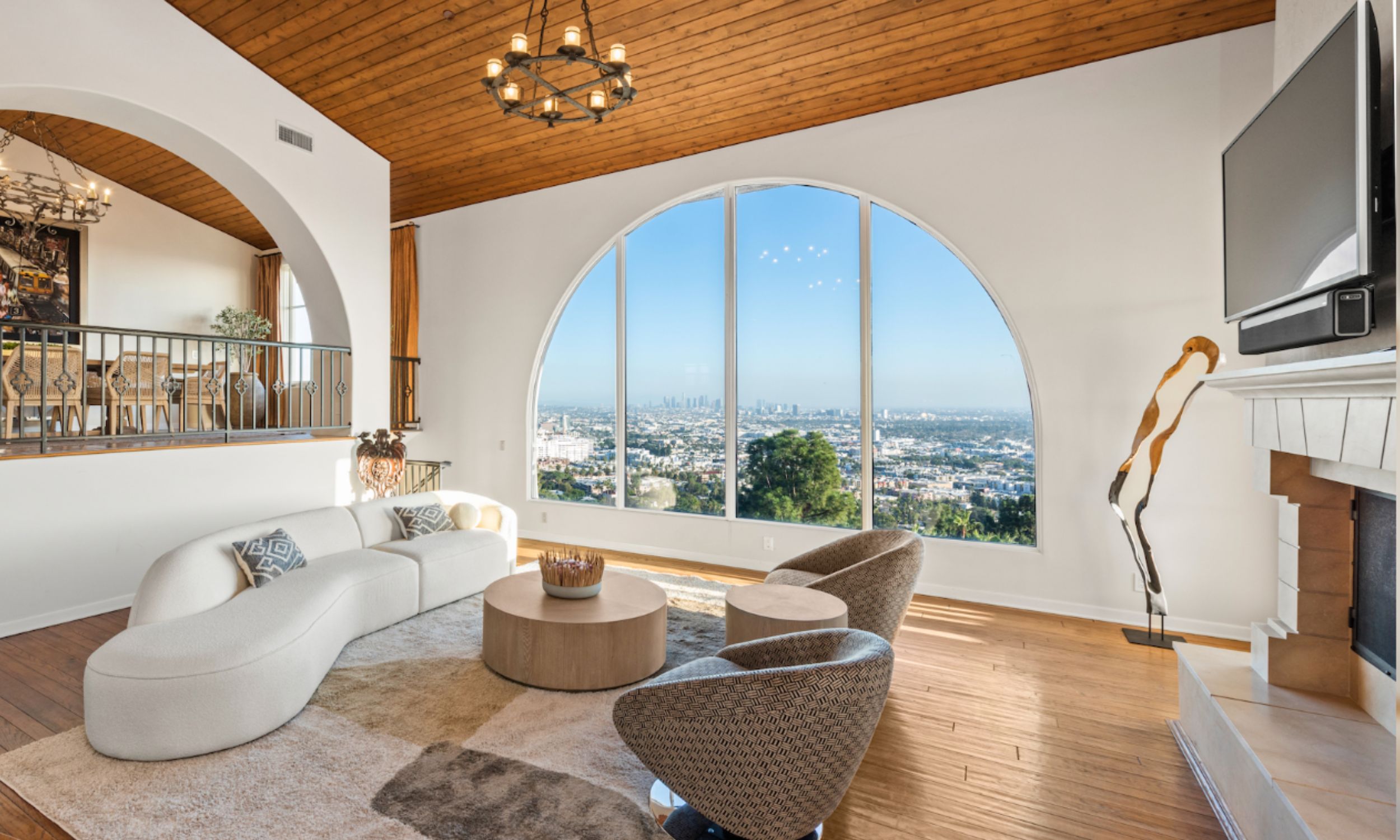 Legacy Healing Center, Wattles – A spacious luxury treatment center for addiction common area featuring a large arched window with panoramic city views, comfortable seating, warm wood ceilings, and natural light, designed to support healing and recovery in a serene environment.