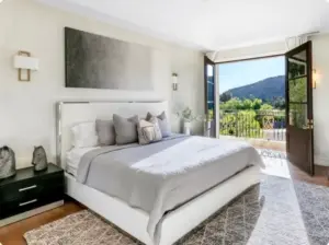 Luxury detox bedroom at Castillian treatment center featuring a comfortable bed, natural light, and scenic mountain views.