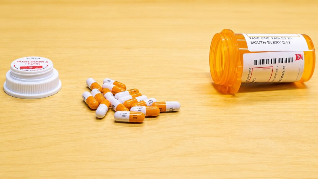 Prescription medication bottle and capsules representing Adderall alternatives for ADHD treatment, including stimulant and non-stimulant medication options.